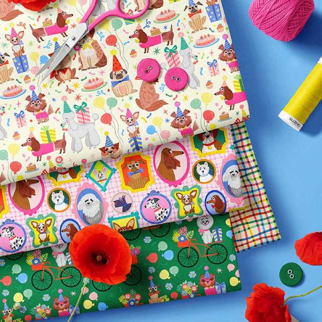 Folded fabric swatches featuring illustrations of dogs in party hats and birthday motifs, illustration by MarushaBelle